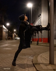 It's true, dancers will stretch anywhere. Roy Chen pauses while taking an evening stroll through Rotterdam. (Photo by Nick Zhao)