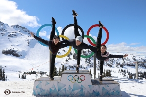 Dancers (from left) Miranda Zhou-Galati, Yiting Huang, and Kaidi Wu pose on the Olympic awards podium. (Photo by William Li)