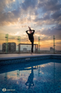 On the hotel's rooftop, dancer Edwin Fu balances by the pool. (Photo by William Li)